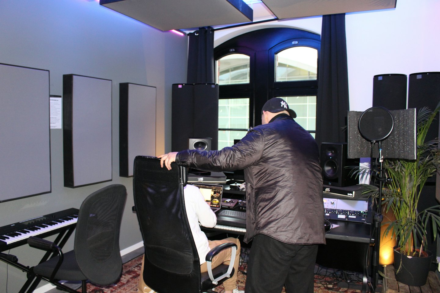 Two men working together in a brightly lit recording studio.