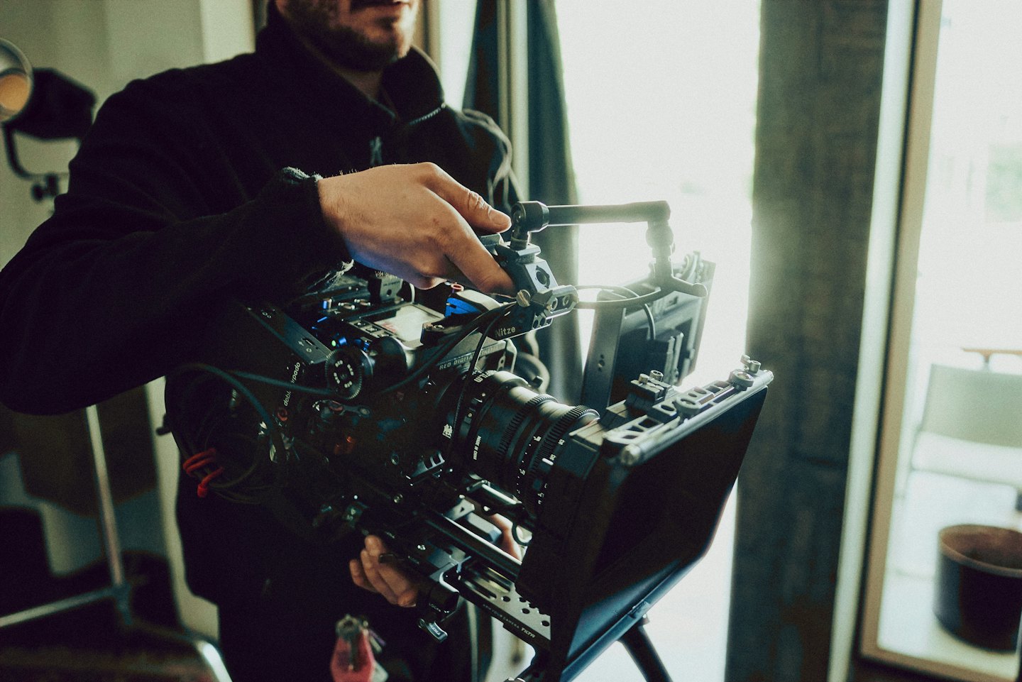 Videographer adjusts controls on a professional cinema camera rig.